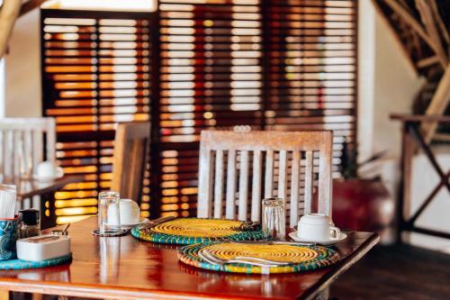 a wooden table with two plates on top at Hekaya Zanzibar in Pingwe