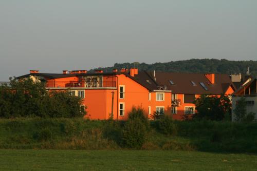 an orange house in the middle of a field at Daisy Superior in Kraków