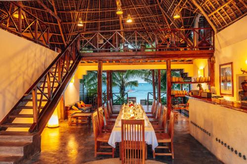a dining room with a long table in a restaurant at Hekaya Zanzibar in Pingwe