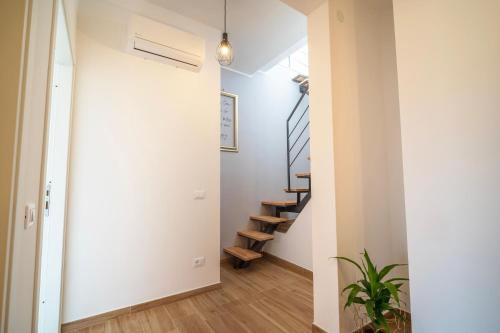 a hallway with a staircase in a home with white walls at La Terrazza Anagni in Anagni