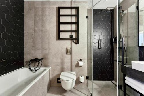 a bathroom with a toilet and a tub and a shower at Crowne Plaza - Warsaw - The HUB by IHG in Warsaw