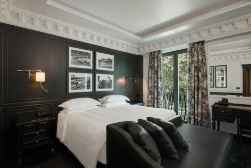 a bedroom with a white bed and a window at Hotel de la Ville Monza - Small Luxury Hotels of the World in Monza