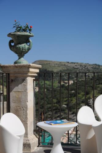 a balcony with a table and two chairs and a vase at Iblainsuite in Ragusa