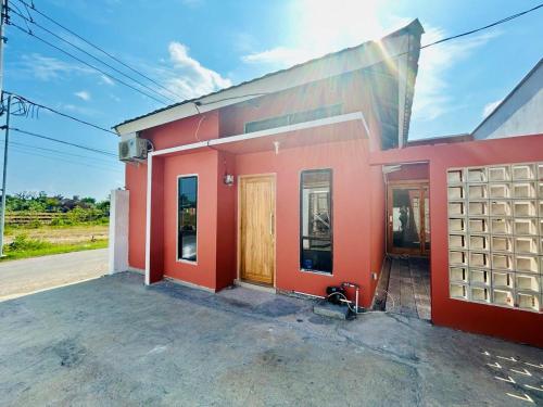 a red and white building with a gate at Tio Homestay in Praya