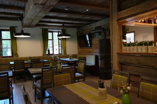 a restaurant with wooden walls and tables and chairs at Ferienwohnung Werraquell Hütte in Masserberg
