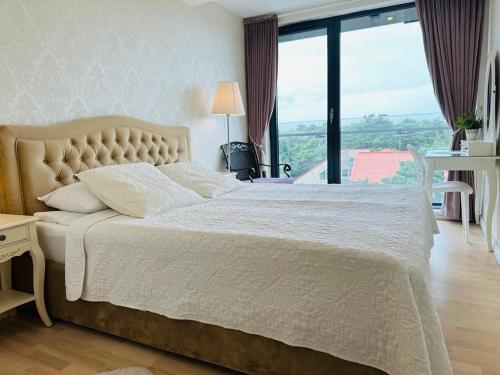 a bedroom with a large bed with a large window at Daukanto Sea View Apartment, by luxuryrent in Palanga