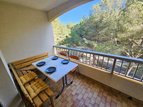 un balcon avec une table, des chaises et une fenêtre dans l'établissement Bel appartement, 4 couchages, lumineux, 500 m de la plage et des commerces..., à Saint-Mandrier-sur-Mer