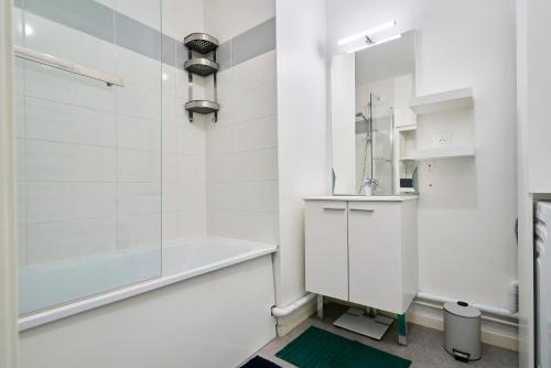 une salle de bain blanche avec une baignoire et un lavabo dans l'établissement Appartement T4 Moderne et Spacieux à Lille, à Lille