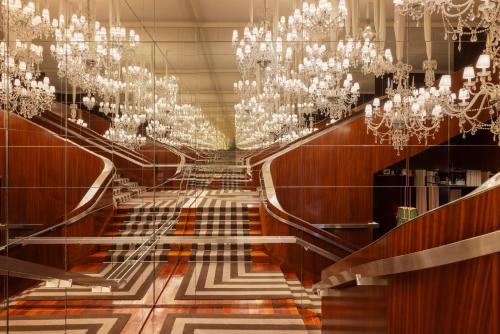 a hallway with chandeliers in a room with a floor at Hôtel Le Royal Monceau Raffles Paris in Paris