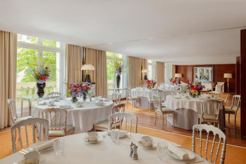 a room with white tables and chairs with flowers on them at Hôtel Le Royal Monceau Raffles Paris in Paris