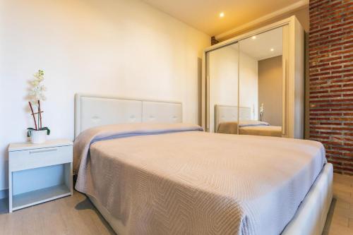 une chambre avec un grand lit et un miroir dans l'établissement Appartamento Etna, à Trecastagni