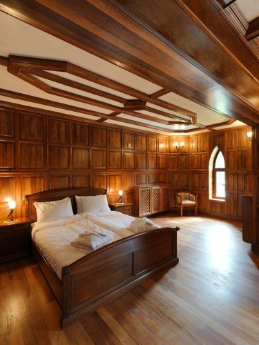 a bedroom with a large bed with wooden walls at The Castle - Your unique way of retreat in Borovets