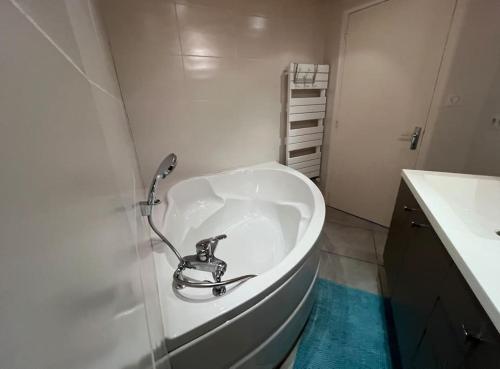 a bathroom with a bath tub with a sink at Villa Vendée EU in Saint-Michel-en-lʼHerm