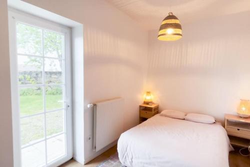a bedroom with a bed and a large window at Villa Vendée EU in Saint-Michel-en-lʼHerm