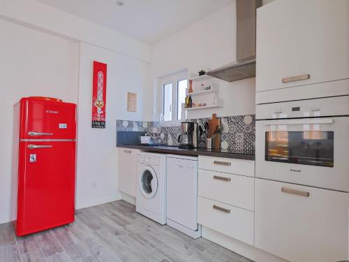 Il comprend une cuisine équipée d'un réfrigérateur rouge et d'un lave-linge. dans l'établissement Les Hortensias, à Perros-Guirec