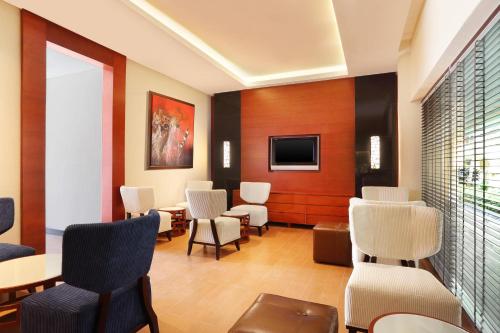 a waiting room with chairs and tables and a tv at The Westin Resort Nusa Dua, Bali in Nusa Dua