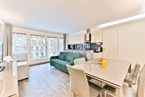 une cuisine et un salon avec une table et un canapé dans l'établissement Appartement ensoleillé proche Buttes Chaumont, à Paris