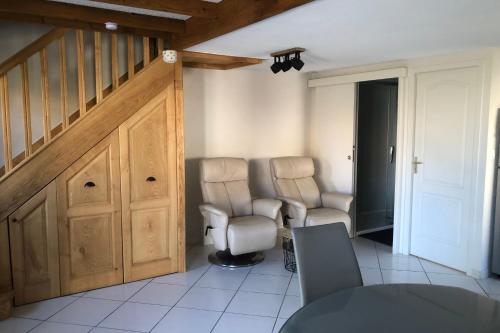 un salon avec deux chaises et un escalier dans l'établissement House with garden and terrace near beach, à Port-la-Nouvelle