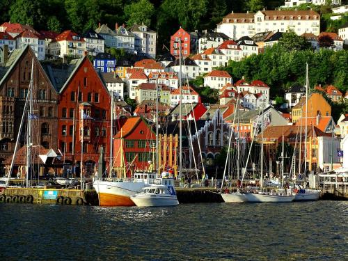 a group of boats docked in a harbor with buildings at Home Hotel Bryggen in Bergen