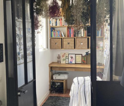 une chambre avec une étagère et une table avec des livres dans l'établissement Cosy flat near the Canal and Paris, à Pantin