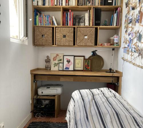 - une chambre avec une étagère et des livres dans l'établissement Cosy flat near the Canal and Paris, à Pantin