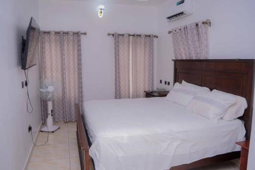 a bedroom with a white bed and a television at Bamgbose Apartments - Sleeps 2 - Balcony - Parking in Surulere