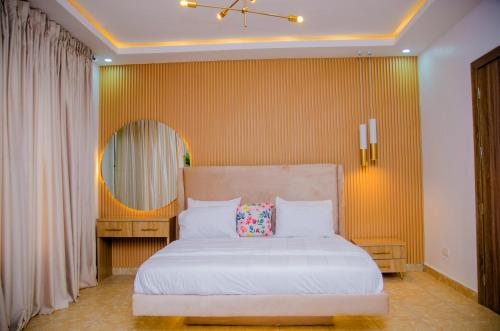 a bedroom with a white bed with a pillow on it at Tranquil Old Bodija Retreat - 3 Bedroom House in Ibadan
