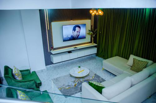 a living room with a couch and a tv at Tranquil Old Bodija Retreat - 3 Bedroom House in Ibadan