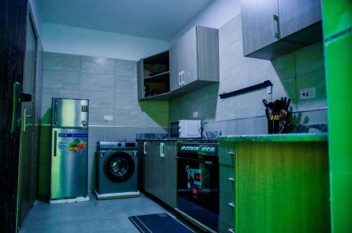 a kitchen with a refrigerator and a washing machine at Tranquil Old Bodija Retreat - 3 Bedroom House in Ibadan