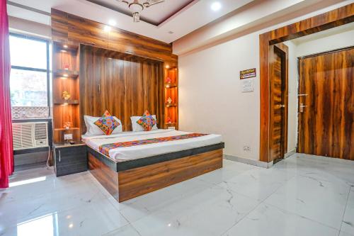 a bedroom with a bed with a wooden wall at FabHotel Imperail House in Prayagraj