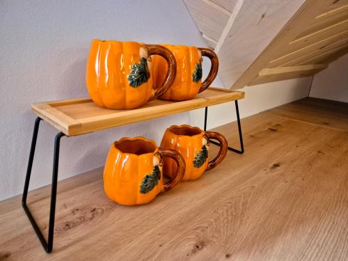 a group of orange mugs sitting on a shelf at Apartament z prywatna wanną hydromasaż - U Parów in Białka Tatrzanska