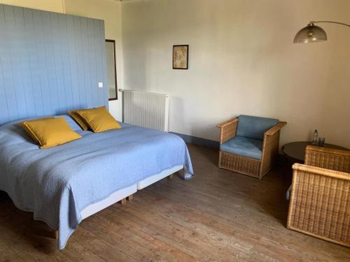 a bedroom with a bed and a chair in it at Domaine La Barbe ! in Lalanne-Arqué