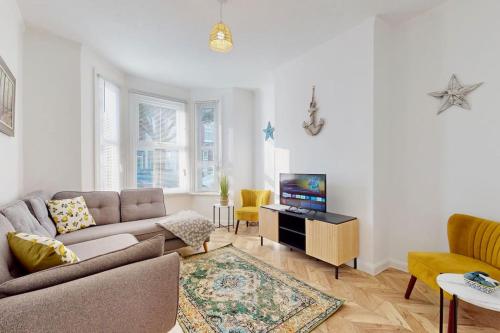 a living room with a couch and a tv at Bright & Spacious 4 Bed Victorian Home by Blue Buzzard Property in Kent