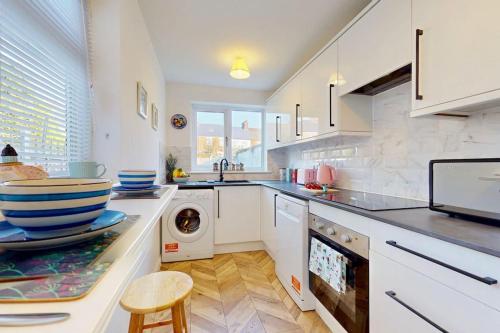 a kitchen with a washing machine and a dishwasher at Bright & Spacious 4 Bed Victorian Home by Blue Buzzard Property in Kent