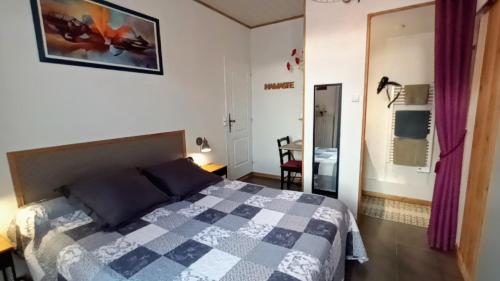una camera con un letto dotato di copriletto a scacchi di Chambre avec terrasse a Pons
