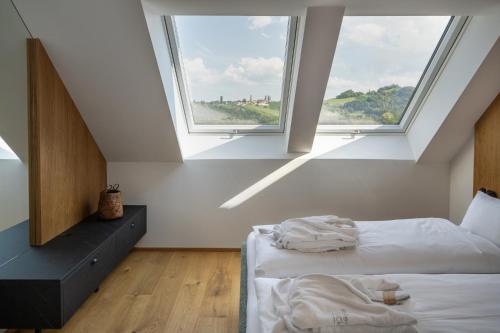a bedroom with two beds and two windows at steiRerBLiCke - Domaine Sernau Sauvignon in Gamlitz