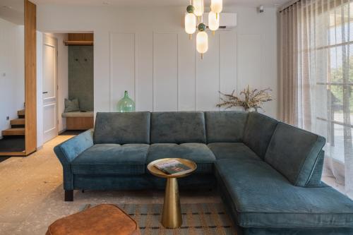 a living room with a blue couch and a table at steiRerBLiCke - Domaine Sernau Sauvignon in Gamlitz