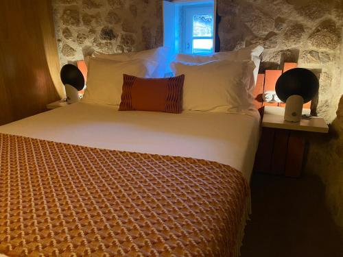 a bedroom with a large bed with white sheets and pillows at Story Studio Sortelha - Heritage in Sortelha