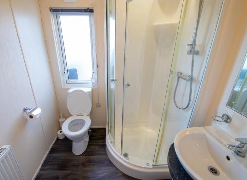 a bathroom with a shower and a toilet and a sink at MP629 Parkdean Camber Sands in Camber