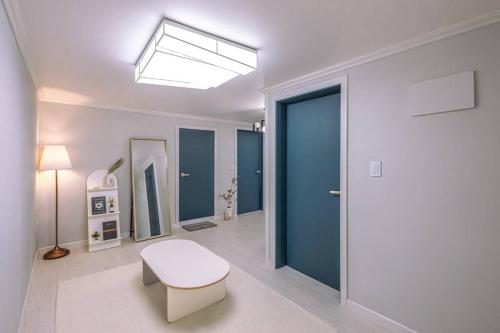 a living room with a blue door and a bench at 인천 간석동 머니스테이 in Incheon