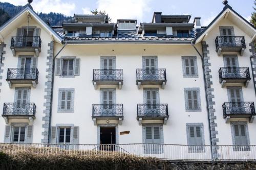 - un grand bâtiment blanc avec balcon dans l'établissement Charming city-centre studio - Mont Blanc view, à Chamonix-Mont-Blanc