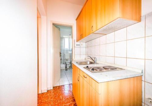 kuchnia ze zlewem i kuchenką w obiekcie Apartments Matulo w Novalji