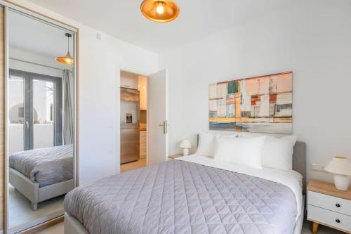 a white bedroom with a bed and a mirror at Mykonos Luxury Apartment with Jacuzzi in Mýkonos City