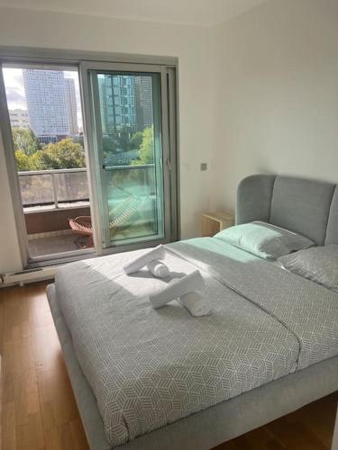 ein Schlafzimmer mit einem Bett und einem großen Fenster in der Unterkunft Tour Eiffel terrasse vue seine in Paris