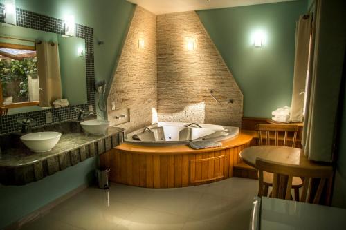 uma grande casa de banho com banheira e lavatório em Hotel Guanxi em Monte Verde
