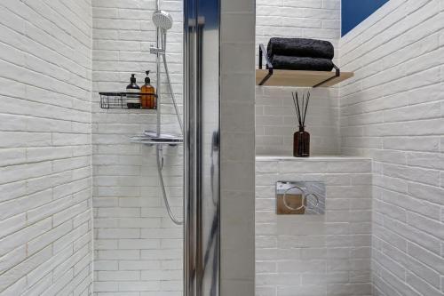une salle de bain blanche avec une douche et un lavabo dans l'établissement Le Dark, à Paris