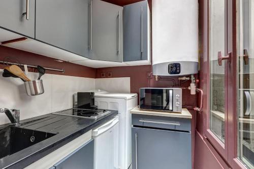 une petite cuisine avec une cuisinière et un micro-ondes dans l'établissement Le Dark, à Paris