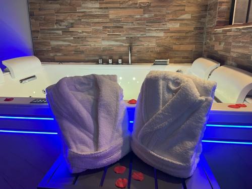 a bathtub with two padded seats in front of it at L'Écrin d'Azurite in Saint-Clair-sur-les-Monts