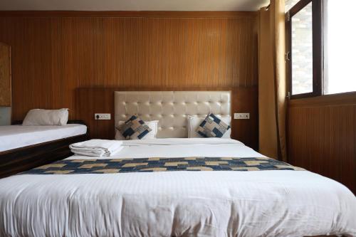 a bedroom with two twin beds and a window at Sleeping Beauty Hotel Moutain view property in Joshīmath