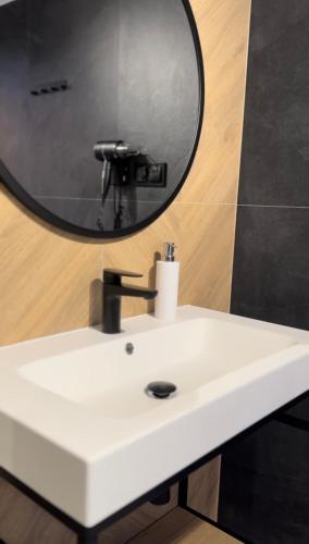 a bathroom with a white sink and a mirror at Hotel Panorama Nowy Sącz in Nowy Sącz